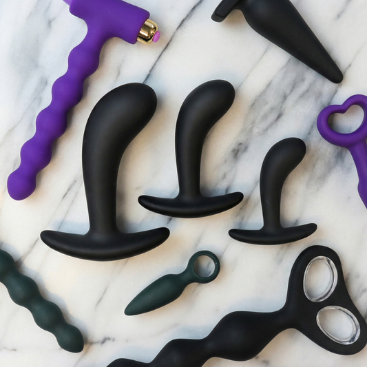 Assortiment buttplugs en anal beads voor beginners op een elegante achtergrond met zachte kleuren en stijlvolle presentatie