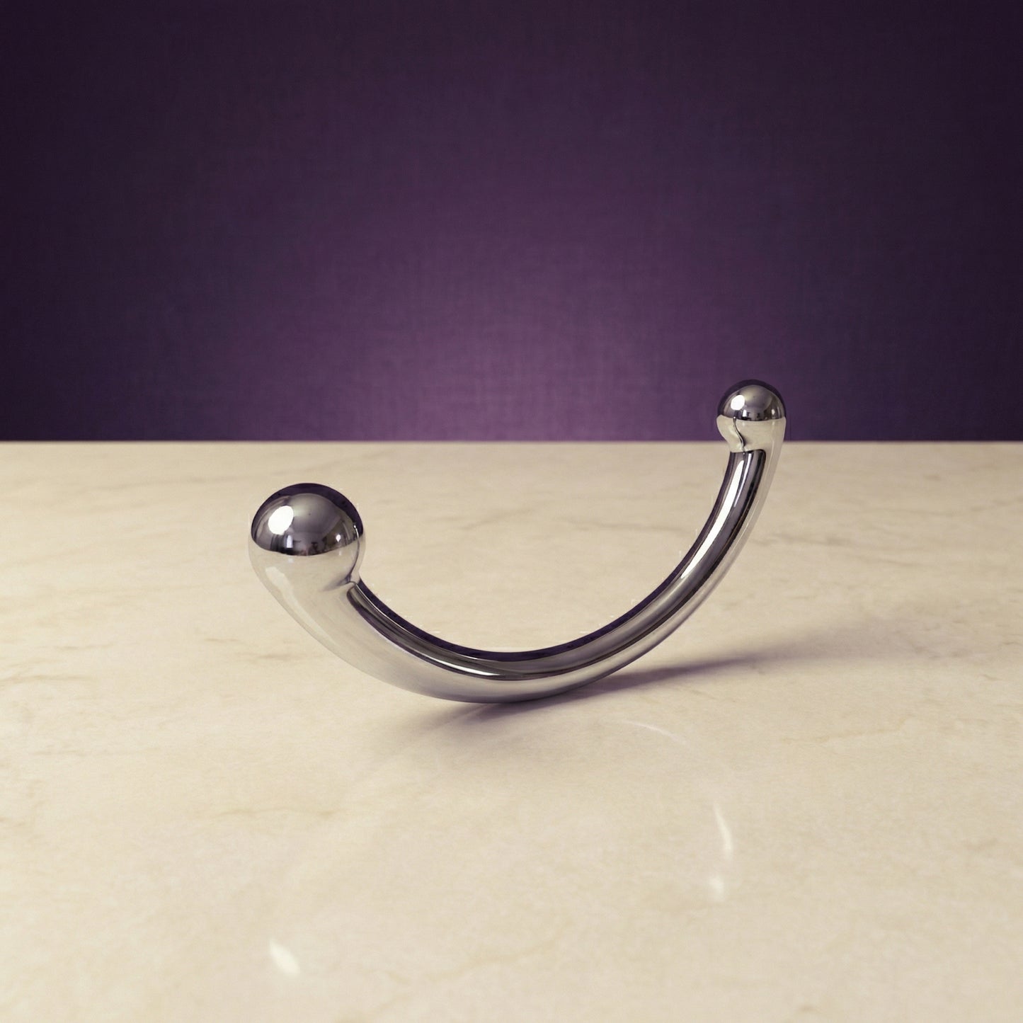 Zijaanzicht van glanzende metalen Joy wand met ergonomische vorm voor intiem gebruik