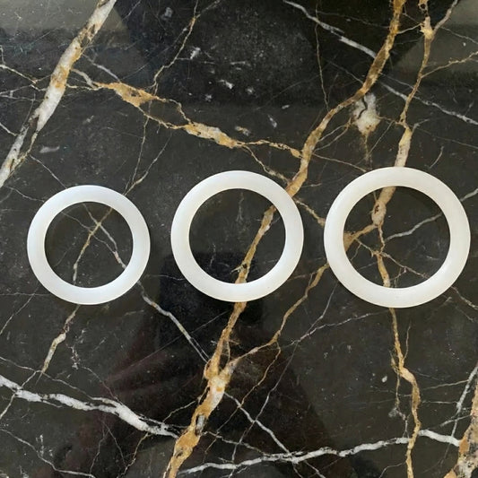 Witte cockring set van De Paarse Keizerin met drie verschillende maten op neutrale achtergrond