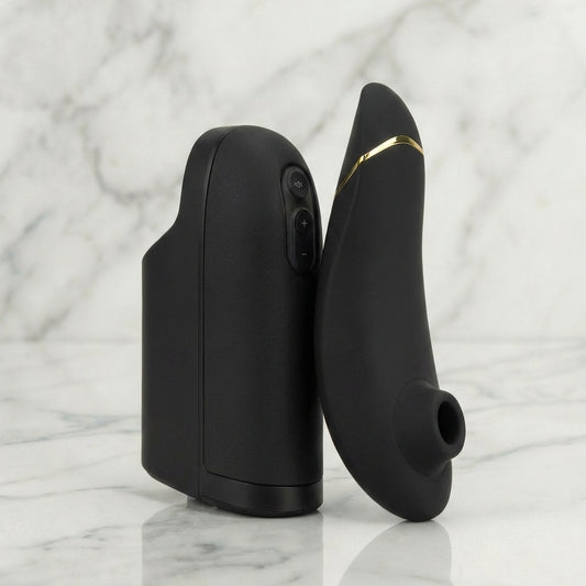 Zwarte Arcwave en Womanizer Pleasure Pair Set naast elkaar op marmeren ondergrond, gouden accenten