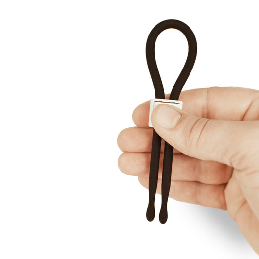 Verstelbare zwarte siliconen lasso cockring met schuifgesp, vastgehouden in hand