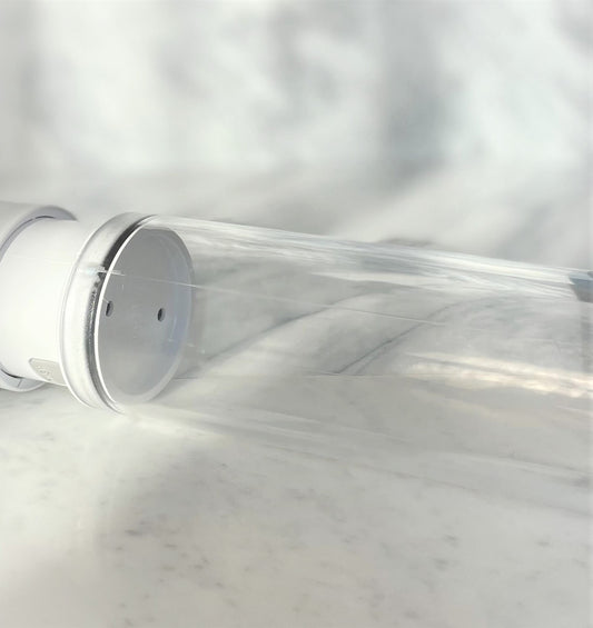 Close-up transparante cilinder van Primus penispomp met witte basis op marmeren ondergrond