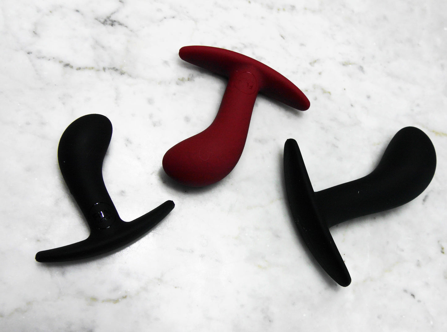 Fun Factory Bootie buttplug set van drie uitgespreid op marmeren ondergrond