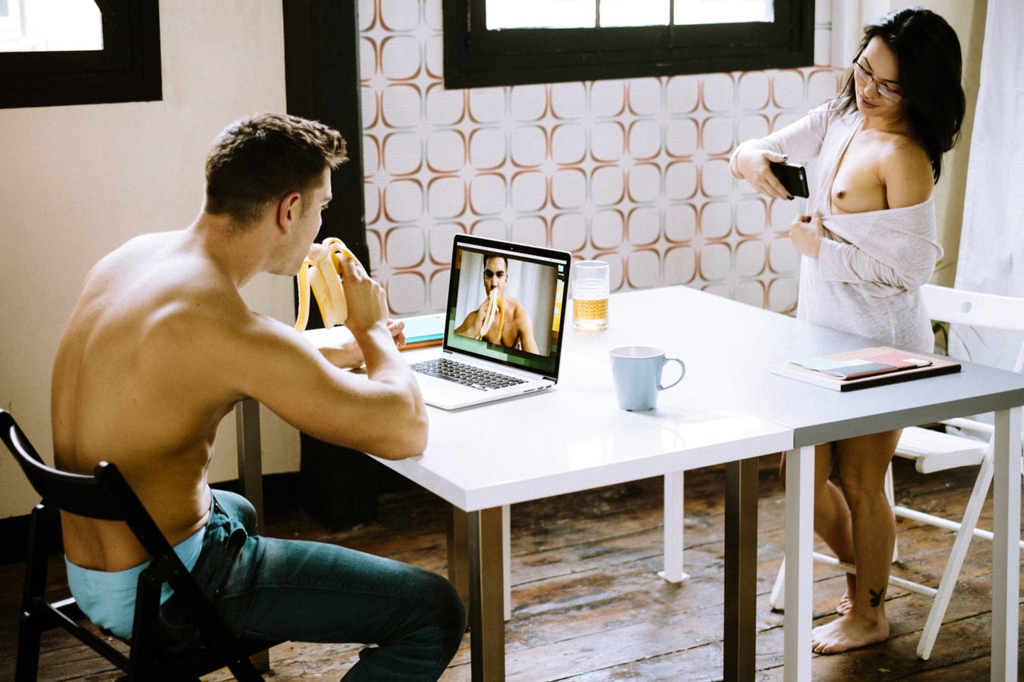 XConfessions Vol. 4 filmstill – man aan tafel met laptop, vrouw maakt selfie