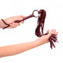 Close-up detail handvat burgundy flogger, toont materiaal en afwerking van het leer