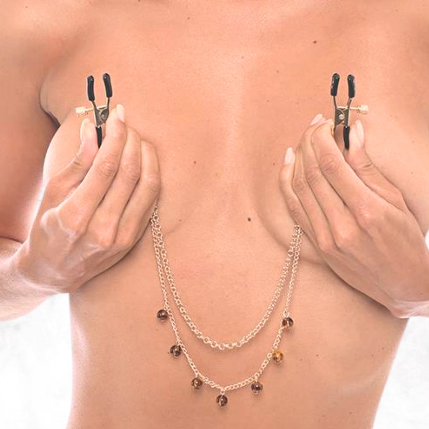 Tepelklemmetjes met goudkleurige ketting en amber steentjes