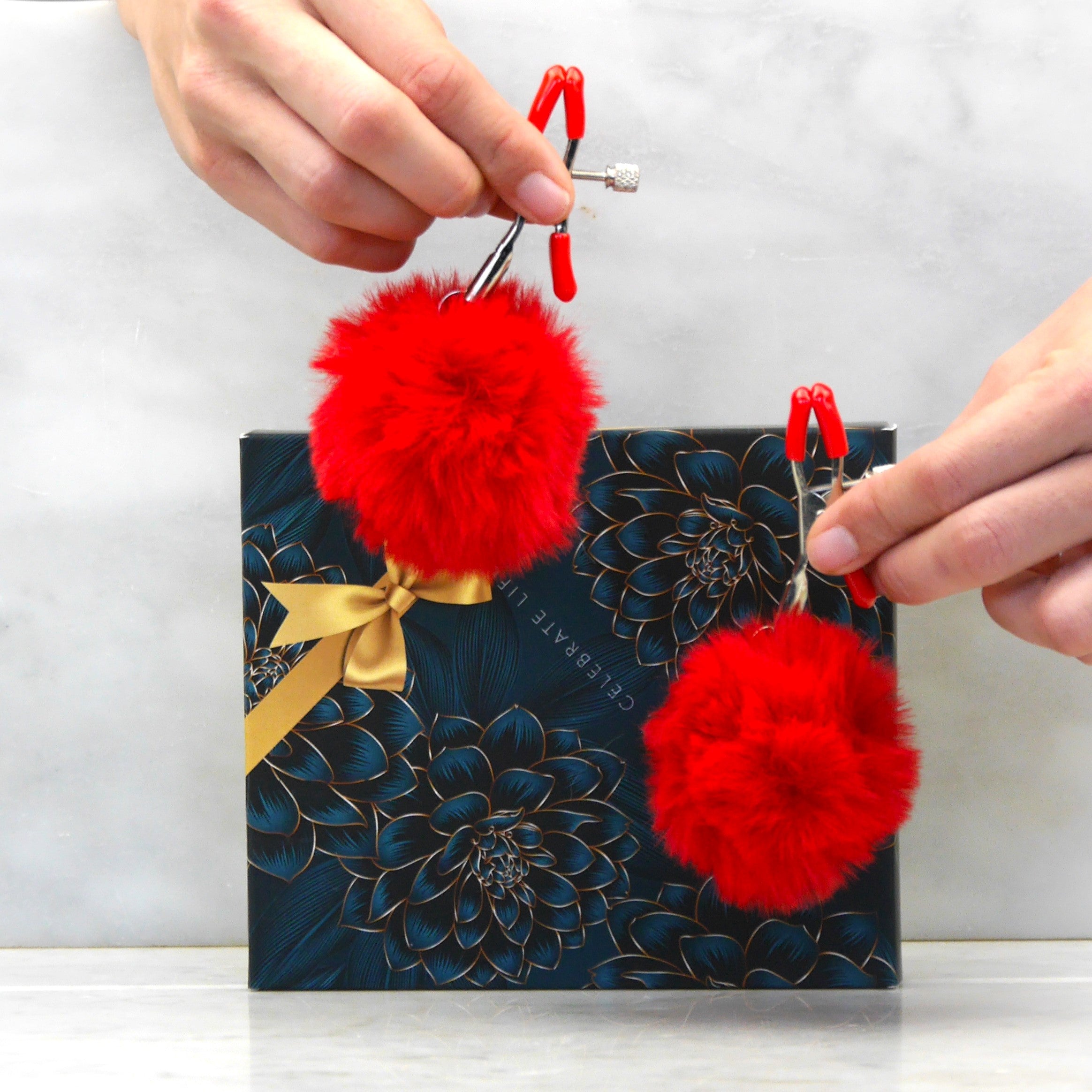 Zijaanzicht van witte tepelklemmetjes met pompoen, toont verstelbare drukknop en ergonomische vorm