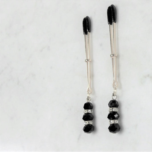 Elegante tepelklemmen met zwarte rubberen uiteinden en decoratieve kralen met strass