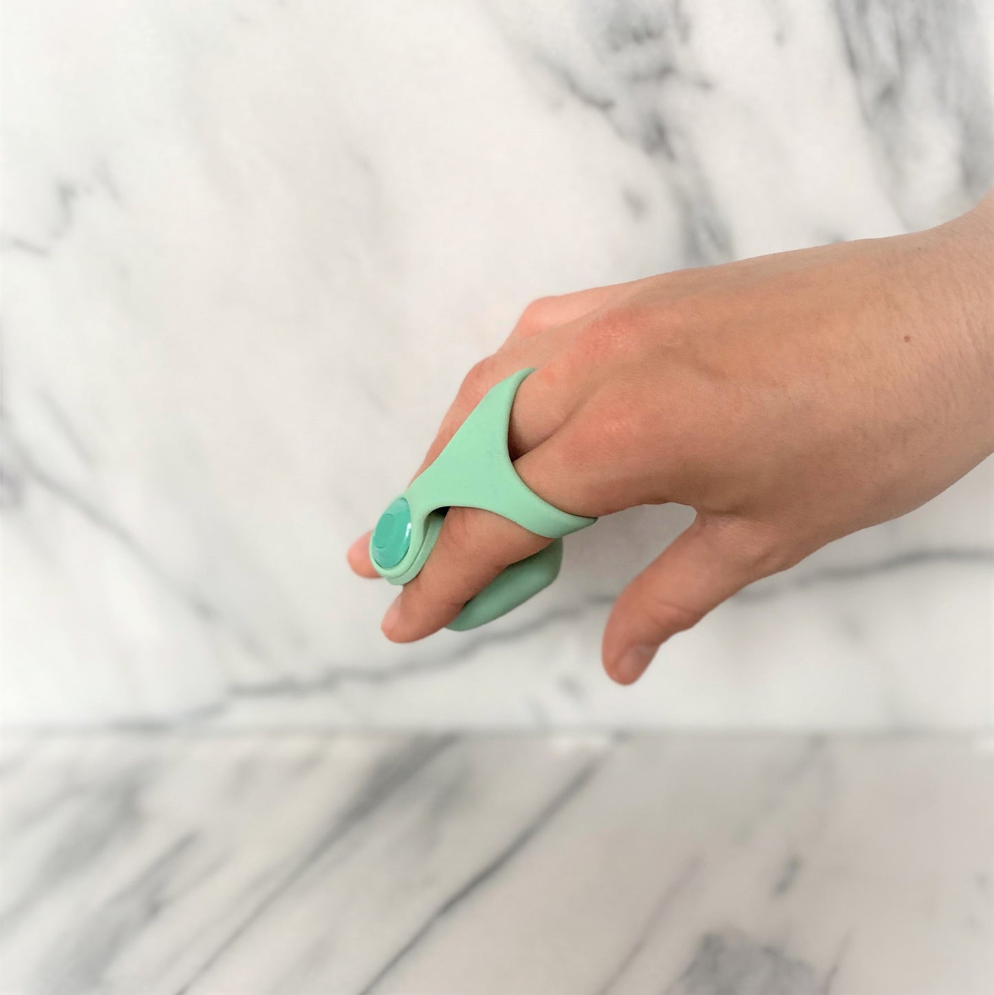 Dame Fin mintgroene vingervibrator om twee vingers gedragen, klaar voor gebruik